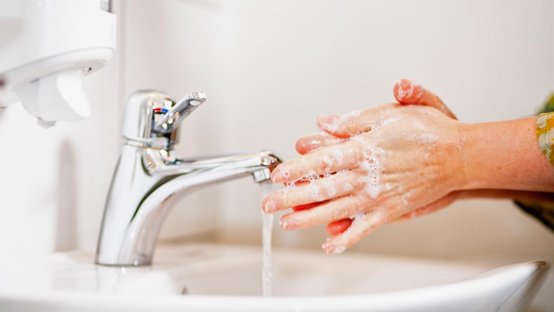 Händer som tvättas i ett handfat.